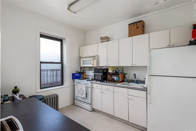 a kitchen with white cabinets and white appliances