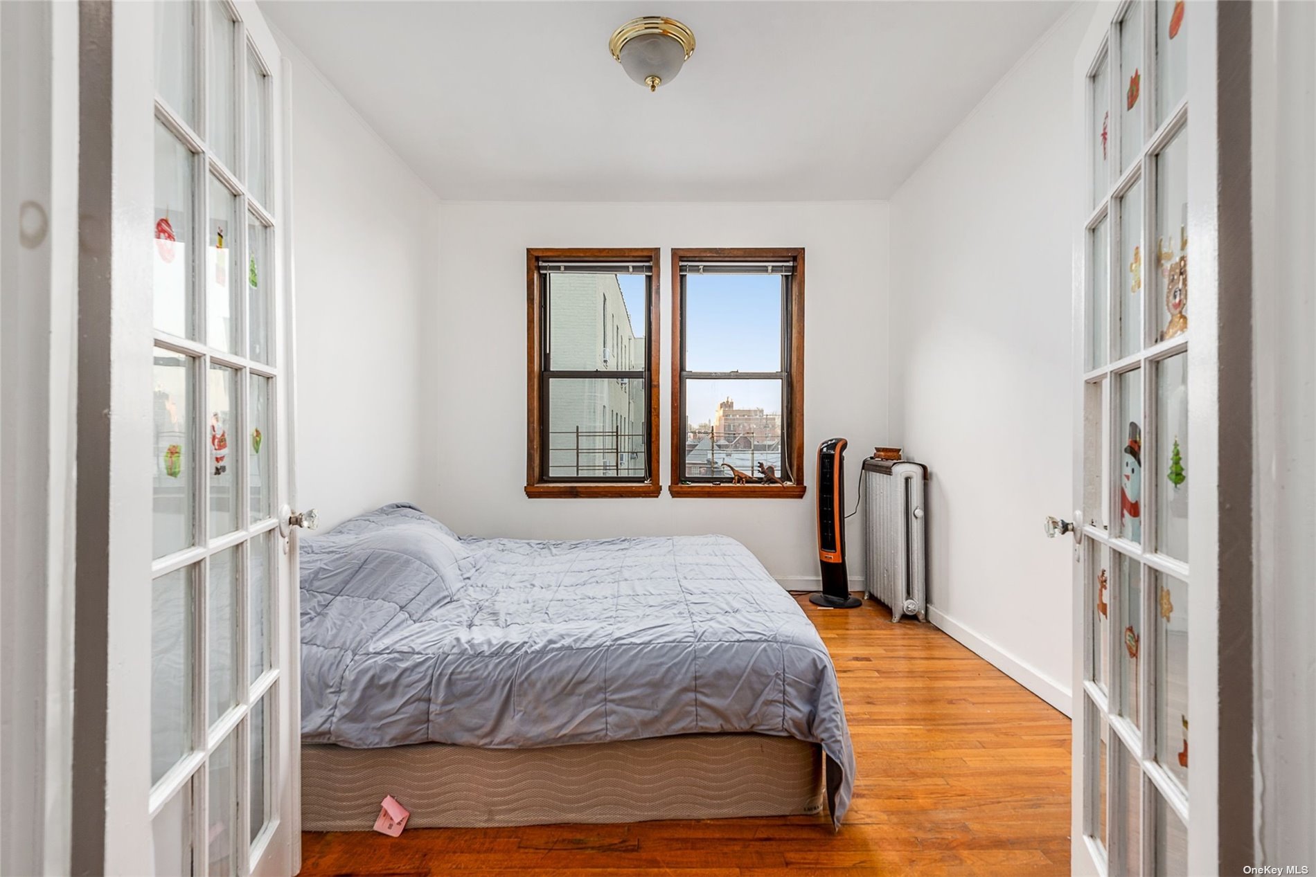 37-68 64th Street Queens, NY 11377 - Photo 10 of 12 a bedroom with a bed closet and a large window