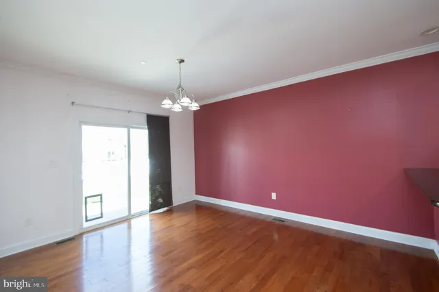 an empty room with windows fireplace and fan