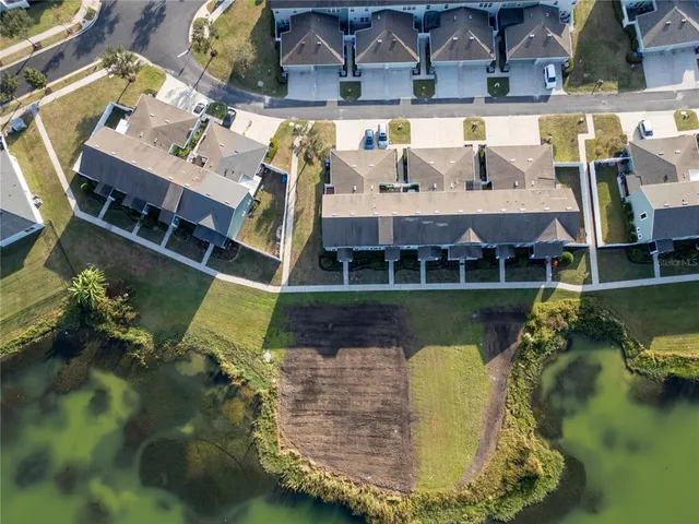 an aerial view of a house with a garden and lake view