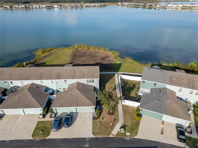 an aerial view of residential houses with outdoor space and lake view