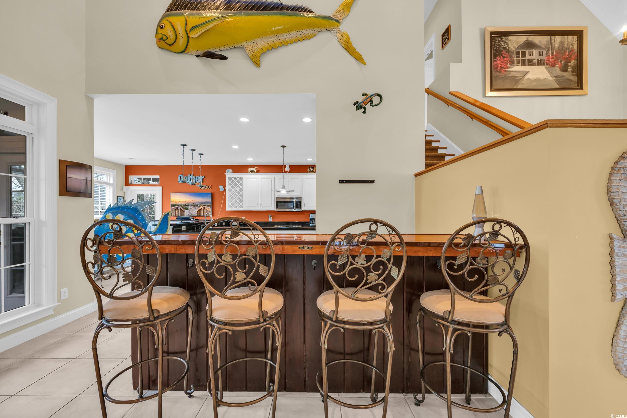830 Channel Cat Cove Murrells Inlet, SC 29576 - Photo 11 of 40 Bar featuring light tile patterned flooring and a high ceiling