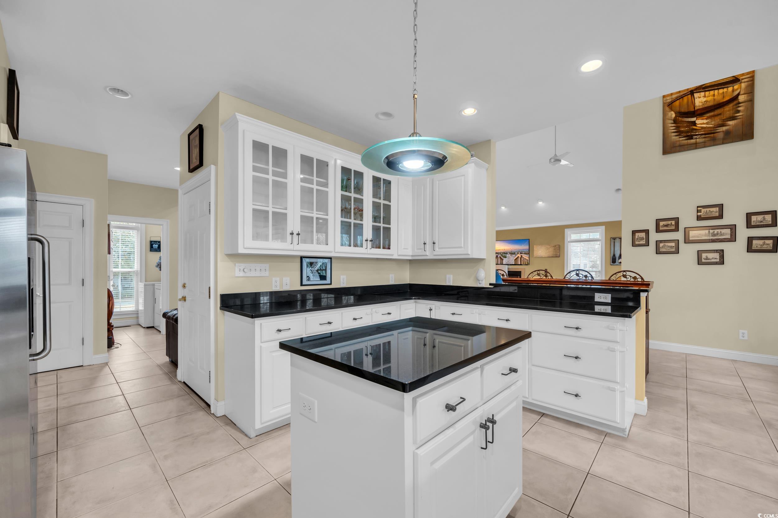830 Channel Cat Cove Murrells Inlet, SC 29576 - Photo 14 of 40 Kitchen with light tile patterned flooring, a center island, white cabinets, and kitchen peninsula