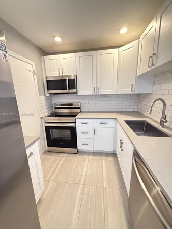 a kitchen with a sink a stove and cabinets