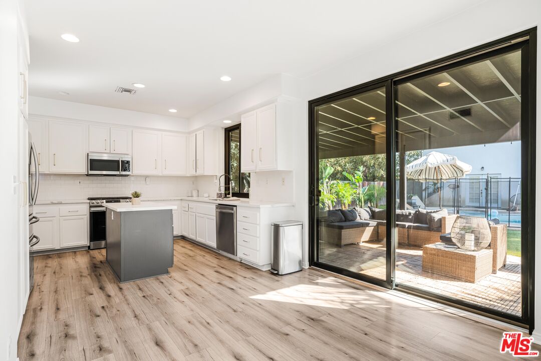 18404 Arminta Street Reseda, CA 91335 - Photo 5 of 13 a kitchen with a refrigerator and a stove top oven