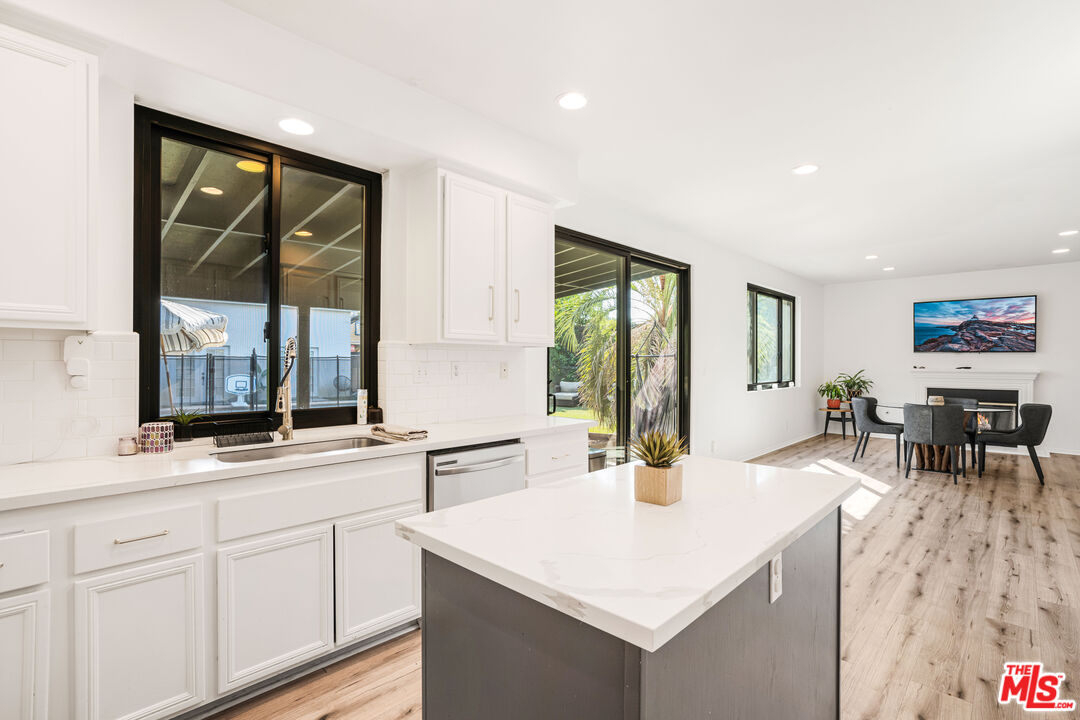 18404 Arminta Street Reseda, CA 91335 - Photo 7 of 13 a kitchen with stainless steel appliances granite countertop a sink and a living room view