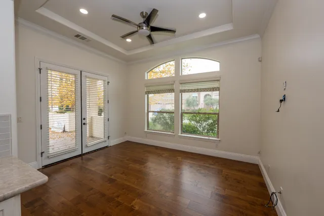 a view of an empty room with a window and wooden floor