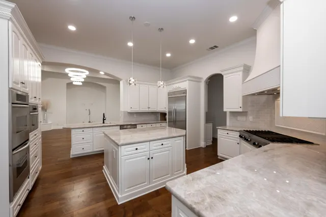a large kitchen with stainless steel appliances kitchen island a sink stove and refrigerator