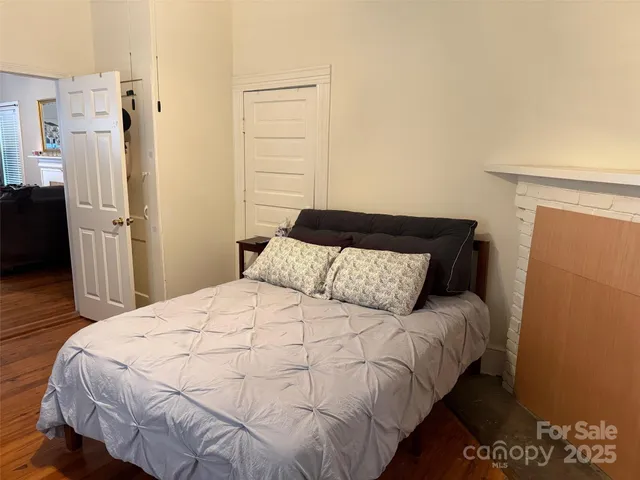 a bedroom with a bed and a refrigerator