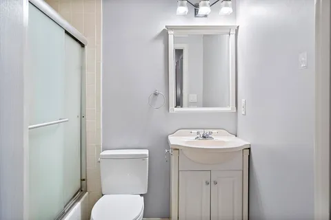 a bathroom with a toilet sink and mirror