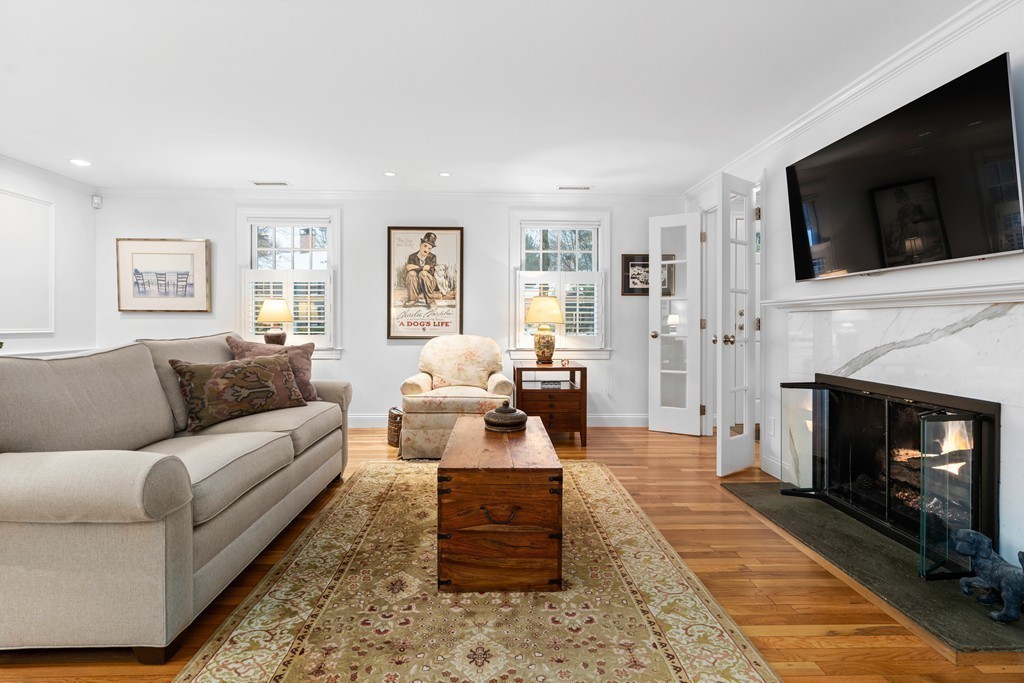 85 Jericho Road, Unit 85 Weston, MA 02493 - Photo 3 of 17 a living room with furniture a flat screen tv and a fireplace