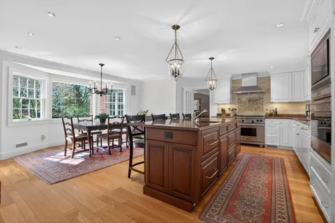 an open kitchen with wooden floor and stainless steel appliances