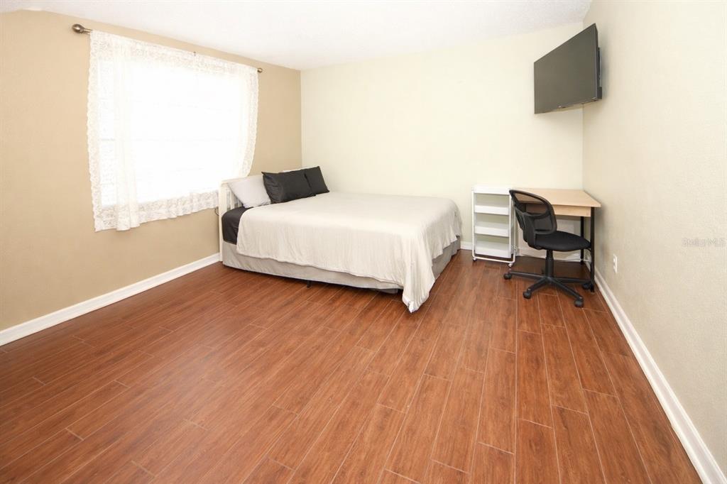 13277 Delbarton Street Spring Hill, FL 34609 - Photo 15 of 22 a bedroom with a bed and a flat screen tv