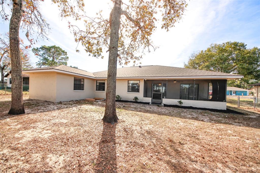13277 Delbarton Street Spring Hill, FL 34609 - Photo 19 of 22 a view of a house with a tree in the yard