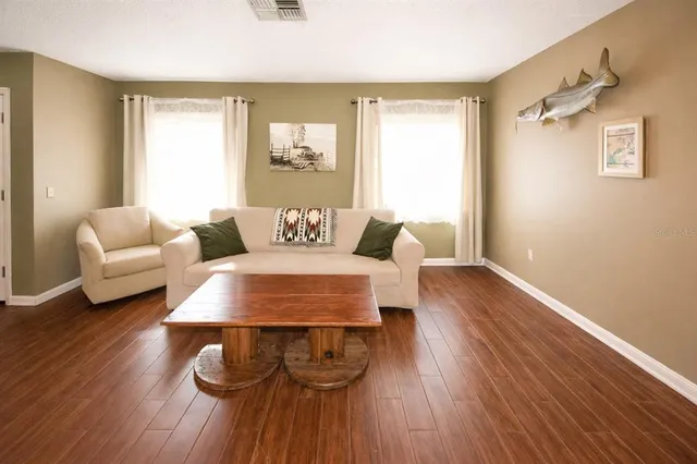 a living room with furniture and a wooden floor