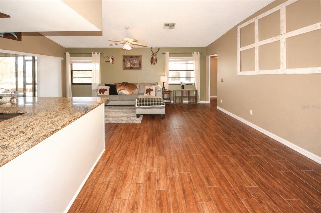 13277 Delbarton Street Spring Hill, FL 34609 - Photo 5 of 22 a living room with furniture and wooden floor
