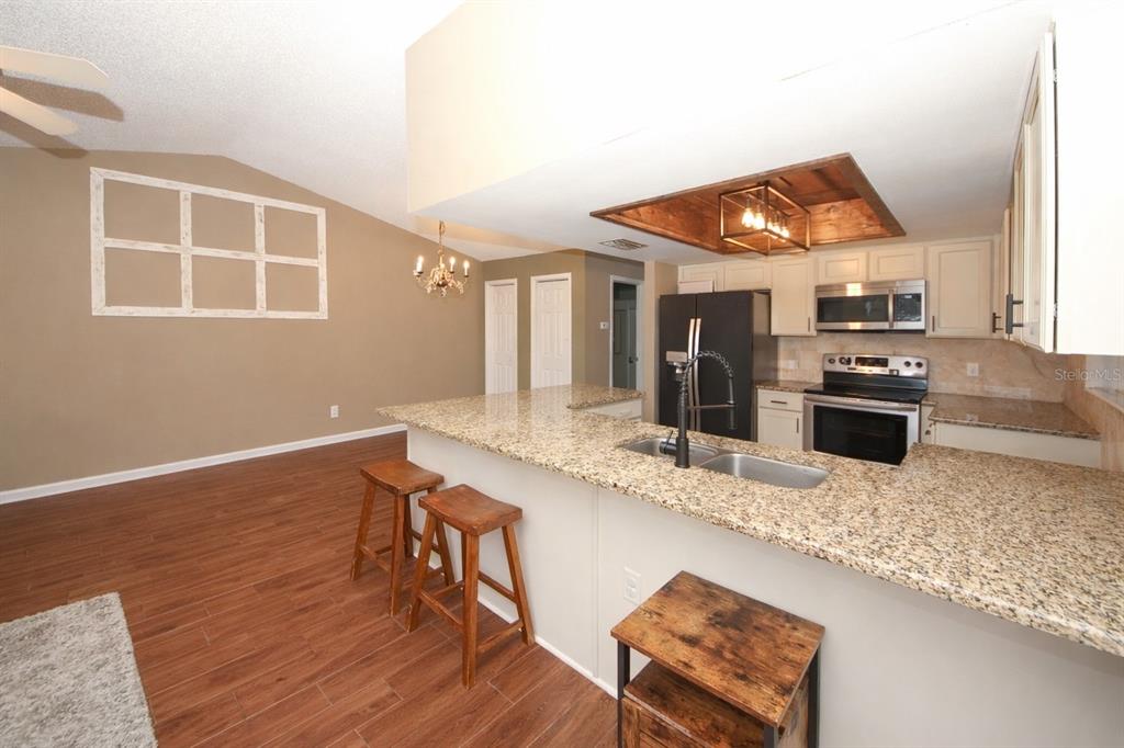 13277 Delbarton Street Spring Hill, FL 34609 - Photo 7 of 22 a kitchen with stainless steel appliances granite countertop a stove a sink and a microwave