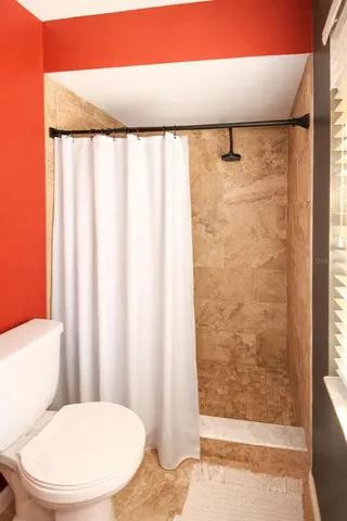 a bathroom with a toilet and shower