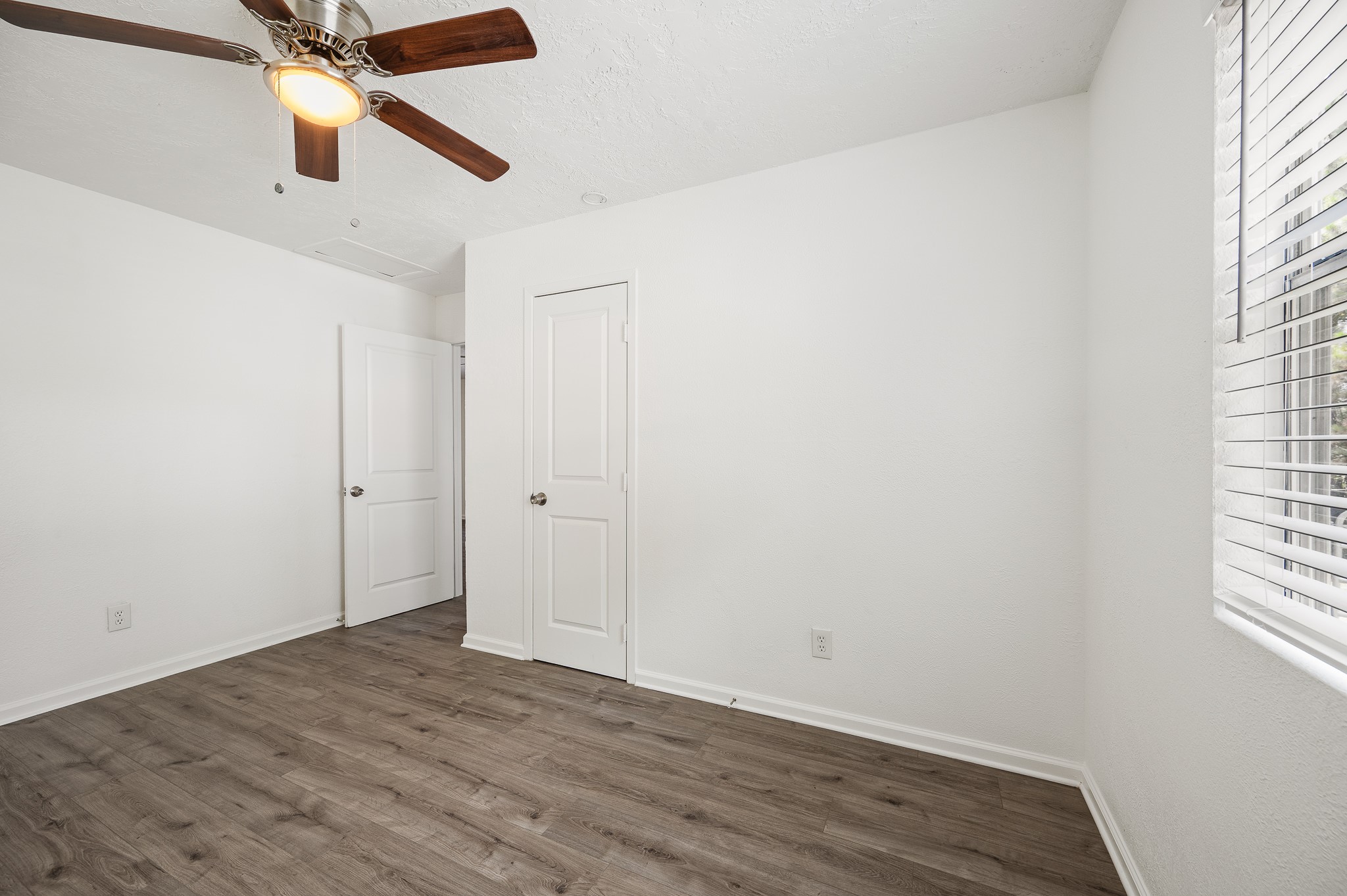 61 Hicks Loop West Cleveland, TX 77328 - Photo 15 of 38 Bright, inviting room featuring sleek hardwood floors, a modern ceiling fan, and ample natural light from large windows.