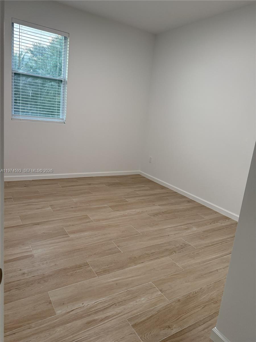 Southwest Ranches Southwest Ranches, FL 33331 - Photo 11 of 12 a view of an empty room with wooden floor and a window