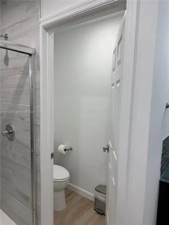 a bathroom with a granite countertop toilet a sink and shower