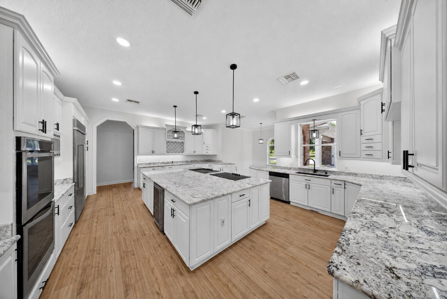 8686 Andrews Avenue Fort Pierce, FL 34945 - Photo 4 of 76 a large kitchen with stainless steel appliances granite countertop a large stove a sink dishwasher and a refrigerator with wooden floor