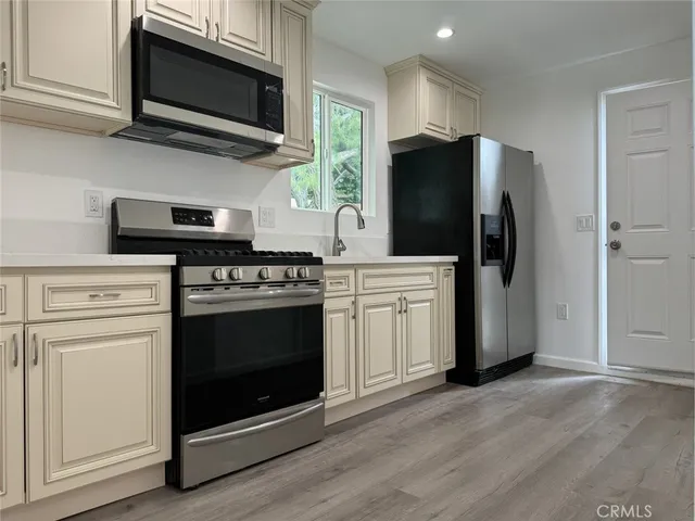 a kitchen with stainless steel appliances a stove a microwave and cabinets