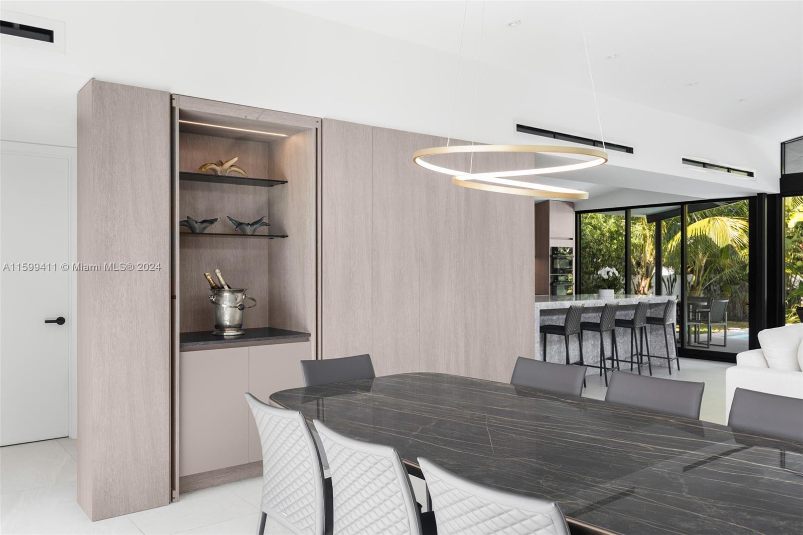 5225 La Gorce Drive Miami Beach, FL 33140 - Photo 14 of 64 a dining room with a wooden table and chairs