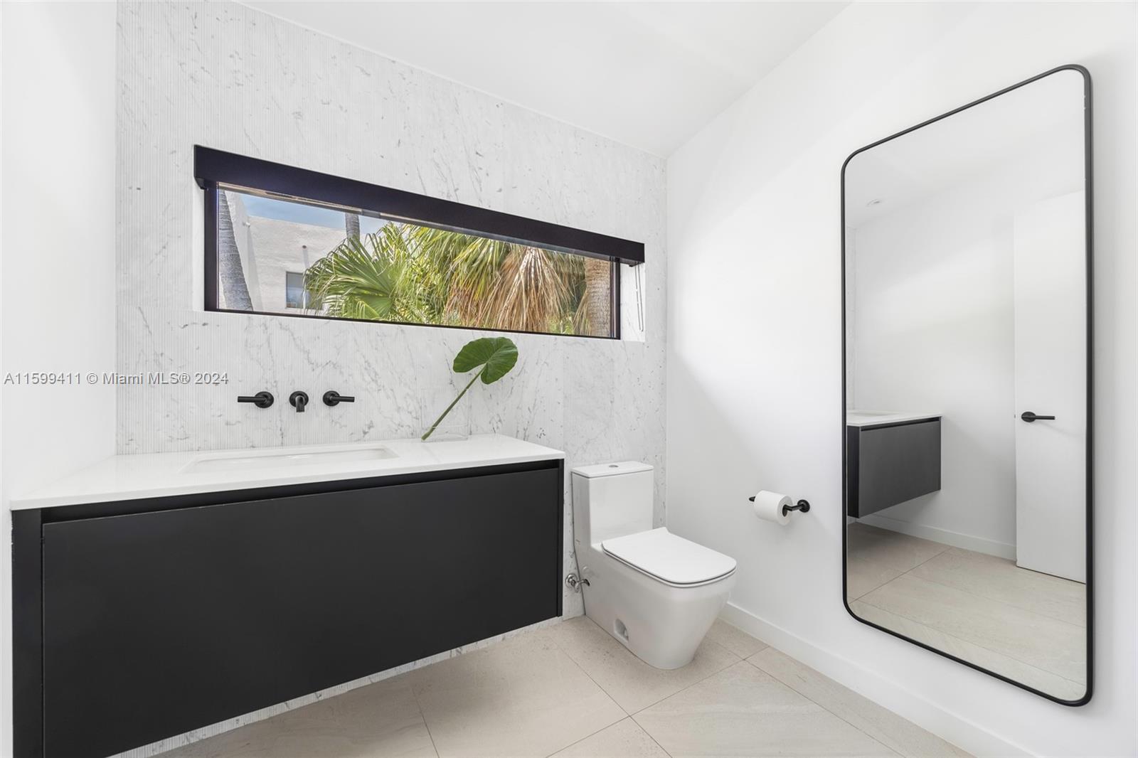 5225 La Gorce Drive Miami Beach, FL 33140 - Photo 38 of 64 a bathroom with a toilet sink and mirror