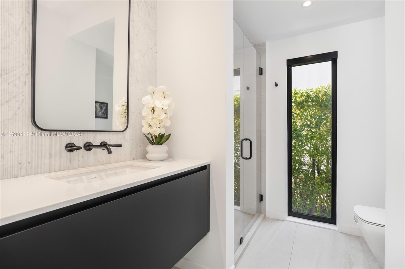 5225 La Gorce Drive Miami Beach, FL 33140 - Photo 40 of 64 a bathroom with a granite countertop sink a toilet a mirror and shower