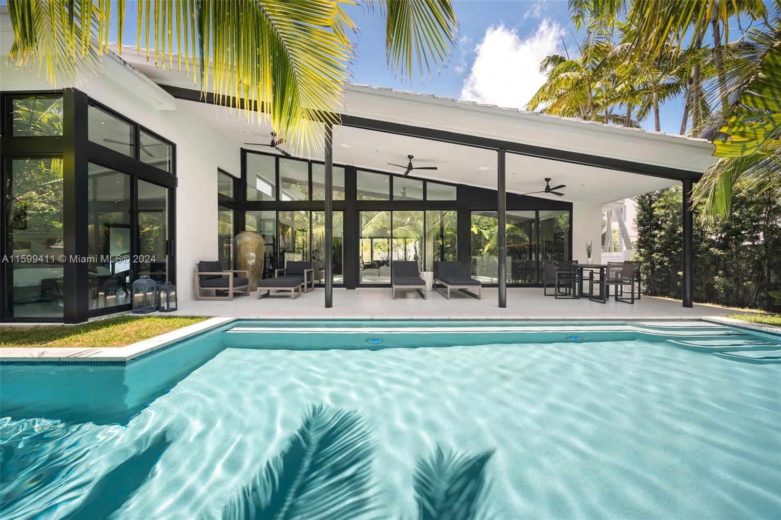 5225 La Gorce Drive Miami Beach, FL 33140 - Photo 51 of 64 a view of swimming pool with outdoor seating and house in the background