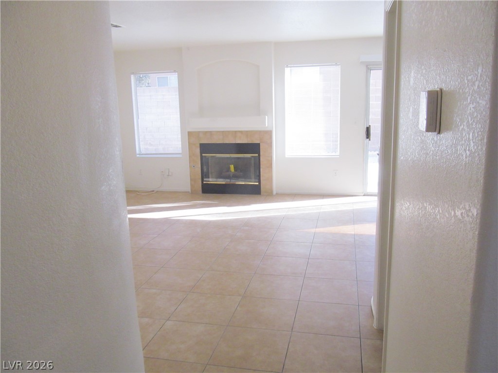 8701 Crescent Ridge Lane Las Vegas, NV 89134 - Photo 12 of 28 Sun-filled living area featuring a cozy fireplace and convenient outdoor access.