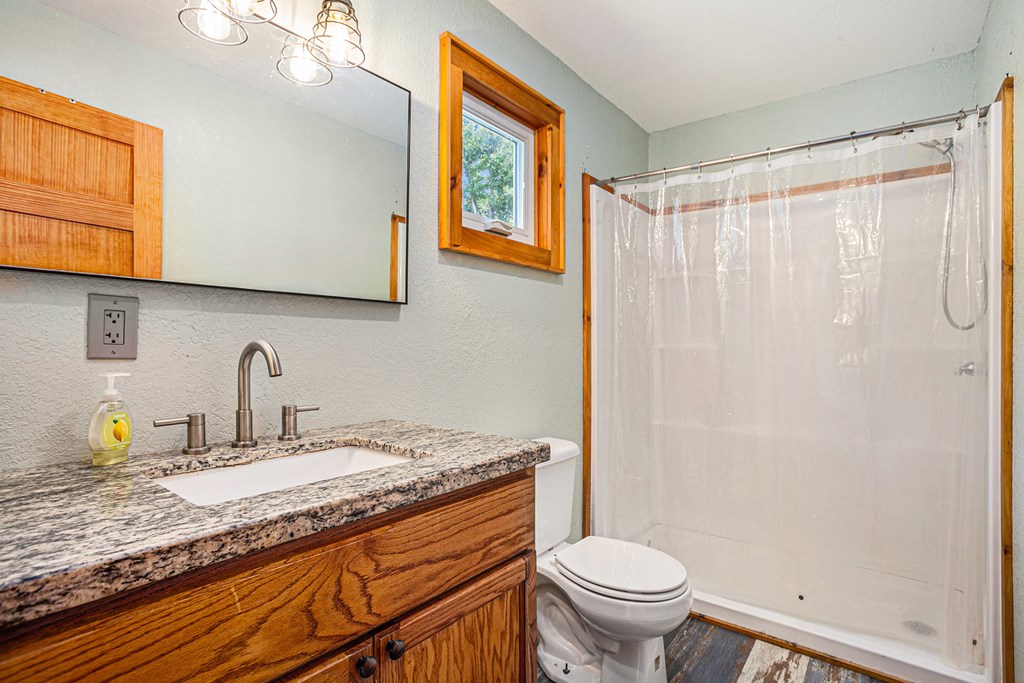 177 Main Street Copperhill, TN 37317 - Photo 18 of 26 a bathroom with a granite countertop sink toilet and a mirror