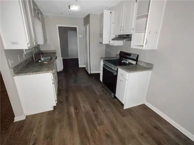 a kitchen with a sink and wooden floor