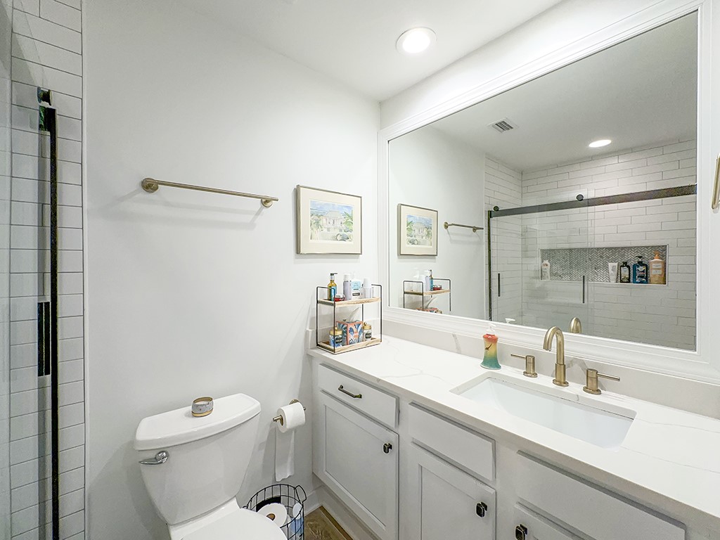 3211 Sea Marsh Road Fernandina Beach, FL 32034 - Photo 16 of 30 a bathroom with a toilet sink double vanity and mirror