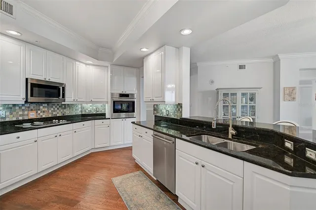 a large kitchen with granite countertop a sink and cabinets