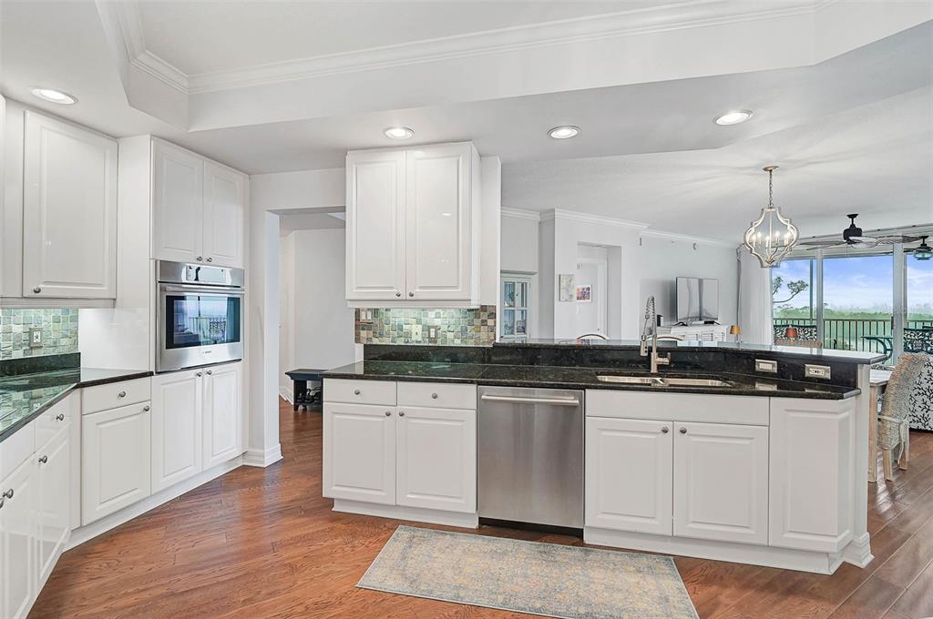 385 North Point Road, Unit 402 Osprey, FL 34229 - Photo 12 of 62 a large kitchen with granite countertop a sink and cabinets