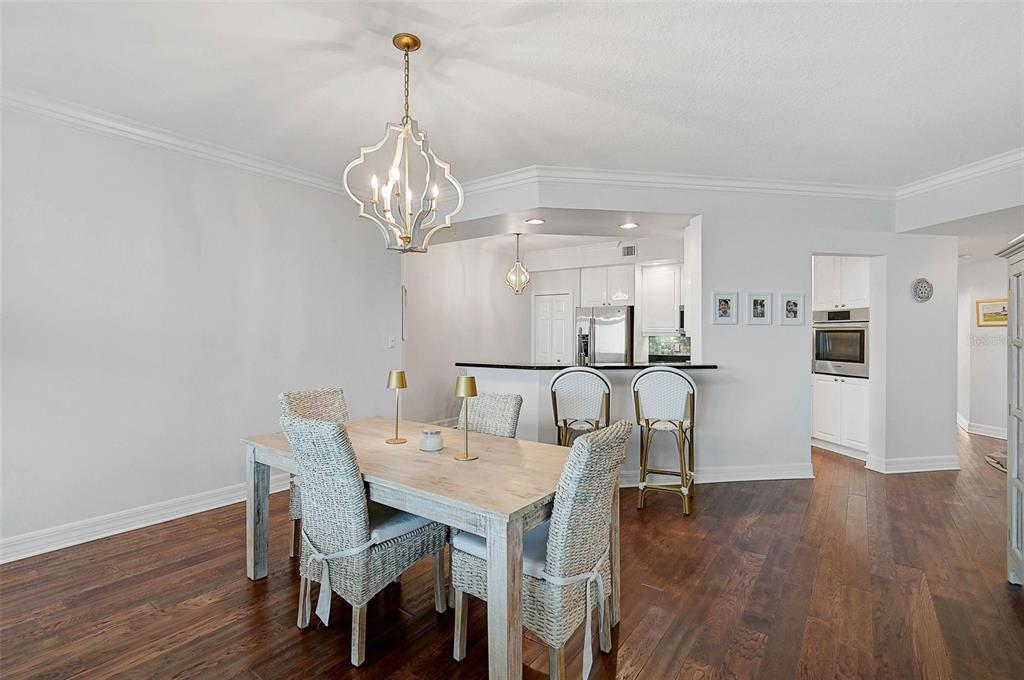 385 North Point Road, Unit 402 Osprey, FL 34229 - Photo 14 of 62 a view of a dining room with furniture wooden floor and chandelier