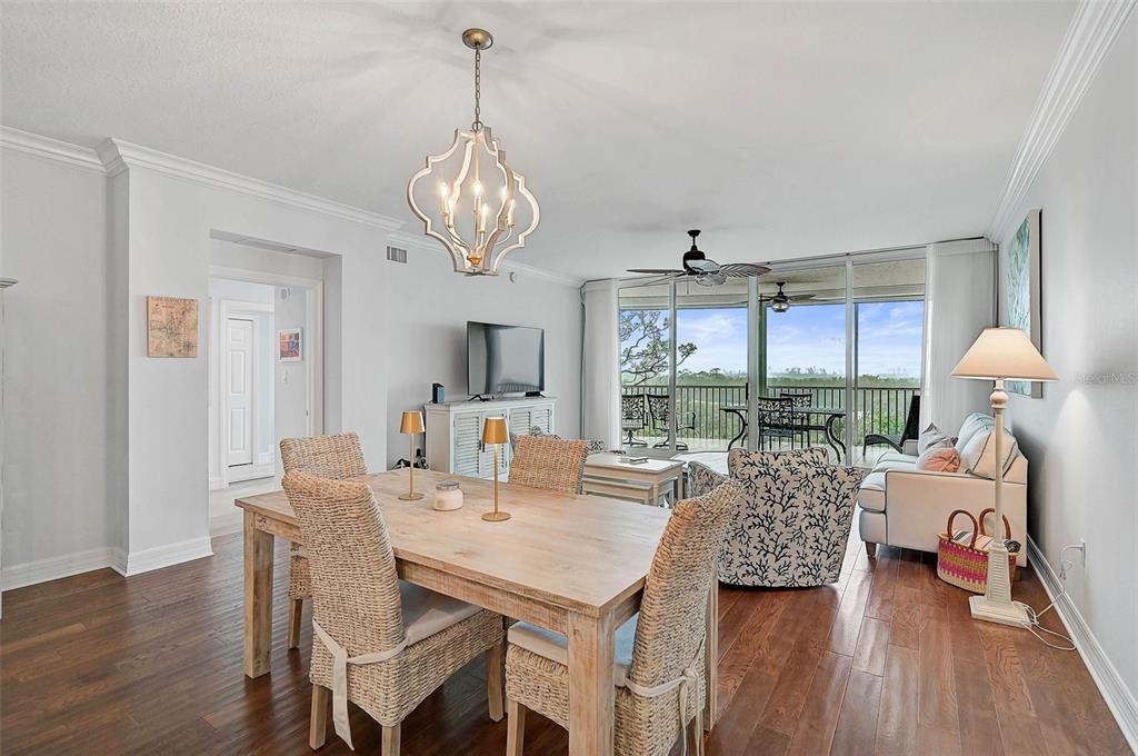385 North Point Road, Unit 402 Osprey, FL 34229 - Photo 15 of 62 a view of a dining room with furniture wooden floor and chandelier