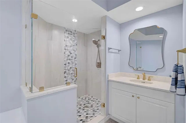 a bathroom with a bathtub a mirror a sink and vanity