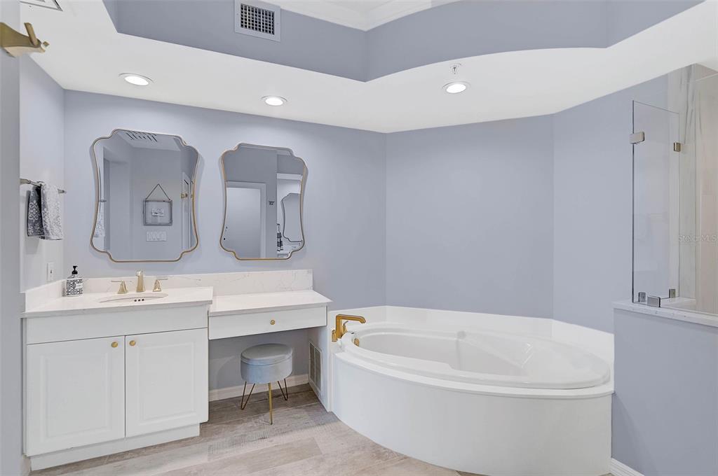 385 North Point Road, Unit 402 Osprey, FL 34229 - Photo 20 of 62 a bathroom with a bathtub a mirror a sink and vanity