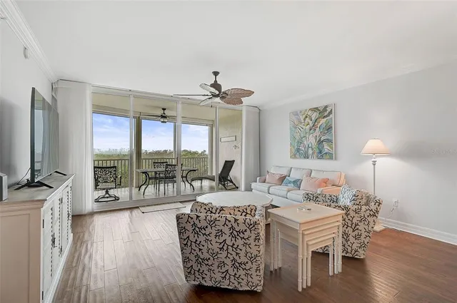 a living room with furniture a flat screen tv and a large window