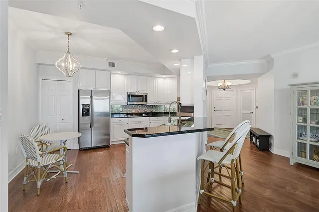 a kitchen with granite countertop a sink and white cabinets