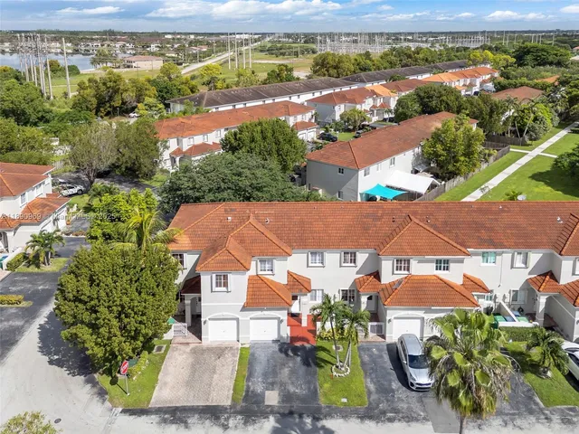 an aerial view of residential houses with outdoor space and ocean view