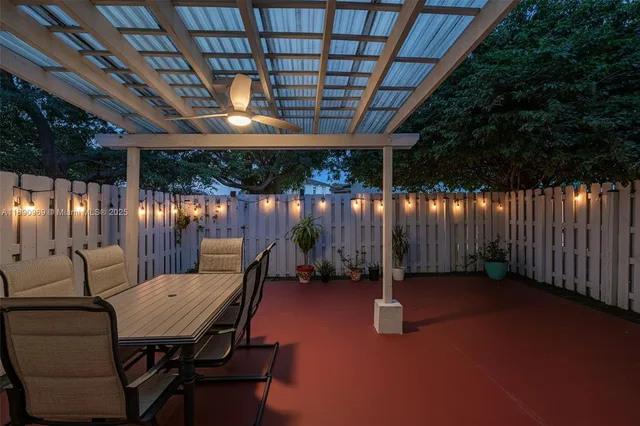 a view of a patio with table and chairs with wooden fence