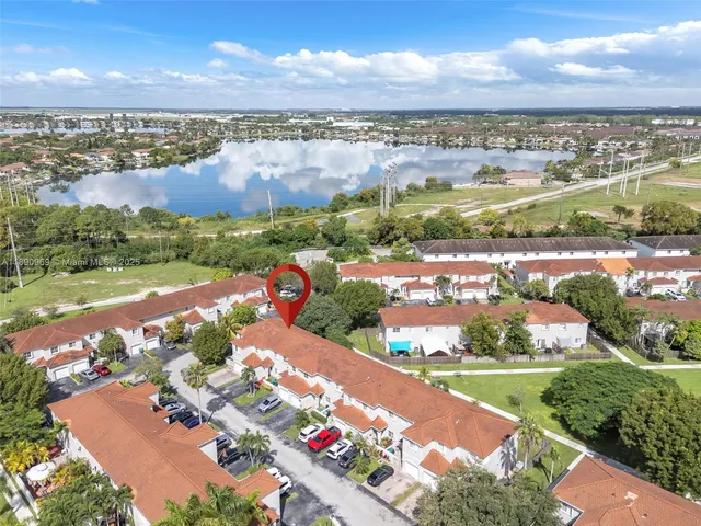 an aerial view of a city with lots of residential buildings ocean and mountain view in back