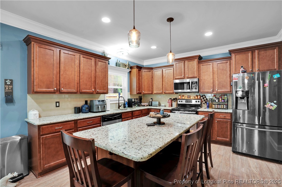 831 Thrush Drive Vass, NC 28394 - Photo 13 of 35 a kitchen with granite countertop a table chairs stainless steel appliances and cabinets