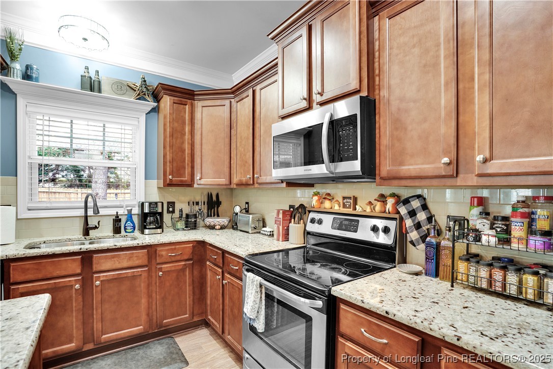 831 Thrush Drive Vass, NC 28394 - Photo 14 of 35 a kitchen with stainless steel appliances granite countertop a stove a sink and a microwave