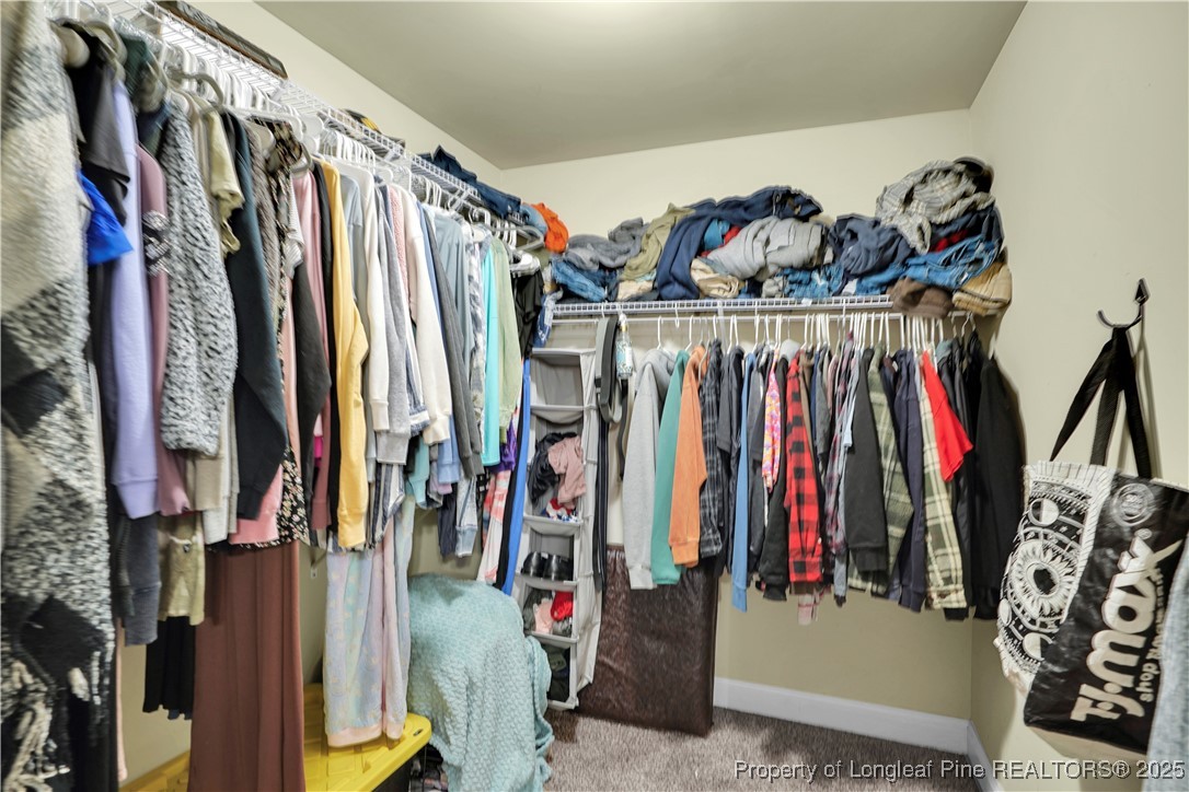 831 Thrush Drive Vass, NC 28394 - Photo 23 of 35 a view of walk in closet with clothes