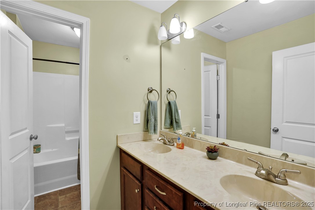 831 Thrush Drive Vass, NC 28394 - Photo 25 of 35 a bathroom with a double vanity sink and a mirror